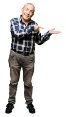 Sticker - Handsome senior man wearing casual shirt amazed and smiling to the camera while presenting with hand and pointing with finger.