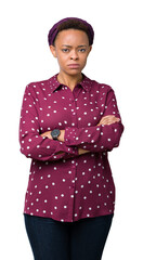 Sticker - Beautiful young african american woman wearing head scarf over isolated background skeptic and nervous, disapproving expression on face with crossed arms. Negative person.