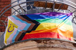 rainbow pride flag progress on balcony house, with black, brown, and blue lines trans flag in chevron form. Created by Daniel Quasar, international LGBT movement, Pride Month