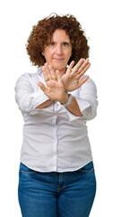 Poster - Beautiful middle ager senior businees woman over isolated background Rejection expression crossing arms and palms doing negative sign, angry face