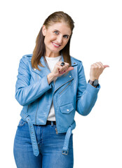 Sticker - Beautiful middle age mature woman wearing fashion leather jacket over isolated background Pointing to the back behind with hand and thumbs up, smiling confident