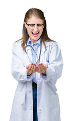 Poster - Middle age mature doctor woman wearing medical coat over isolated background Smiling with hands palms together receiving or giving gesture. Hold and protection