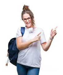 Poster - Young brunette student girl wearing backpack and headphones over isolated background smiling and looking at the camera pointing with two hands and fingers to the side.