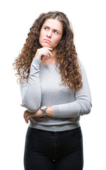 Wall Mural - Beautiful brunette curly hair young girl wearing a sweater over isolated background with hand on chin thinking about question, pensive expression. Smiling with thoughtful face. Doubt concept.