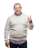 Fototapeta Natura - Handsome senior man wearing winter sweater over isolated background doing happy thumbs up gesture with hand. Approving expression looking at the camera with showing success.