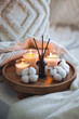 Cozy corner for home meditation, relaxation. Aroma diffuser, burning candles with cotton delicate scent for comfort, pleasure, aromatherapy. Decor for apartment, house, hygge indoors design