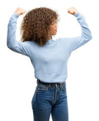 Sticker - African american woman wearing a sweater showing arms muscles smiling proud. Fitness concept.