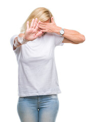 Sticker - Middle age blonde woman over isolated background covering eyes with hands and doing stop gesture with sad and fear expression. Embarrassed and negative concept.