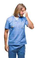 Canvas Print - Young handsome doctor man with long hair over isolated background tired rubbing nose and eyes feeling fatigue and headache. Stress and frustration concept.