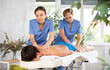 © JackF - Young man is lying on couch and gets massage back treatment performed by two female physiotherapists. Restorative relaxing therapeutic procedures