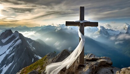 Wall Mural - white satin scarf tied around weathered wooden cross on top of a windswept mountain peak overlooking a range of jagged rocky peaks partially obscured by mist
