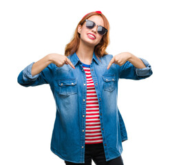 Sticker - Young beautiful woman over isolated background wearing sunglasses looking confident with smile on face, pointing oneself with fingers proud and happy.