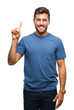 © Krakenimages.com - Young handsome man over isolated background showing and pointing up with finger number one while smiling confident and happy.