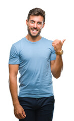 Sticker - Young handsome man over isolated background smiling with happy face looking and pointing to the side with thumb up.