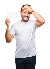 Poster - Young handsome man holding blank card over isolated background stressed with hand on head, shocked with shame and surprise face, angry and frustrated. Fear and upset for mistake.