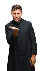 Sticker - Young catholic christian priest man over isolated background looking at the camera blowing a kiss with hand on air being lovely and sexy. Love expression.