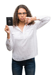 Sticker - Young hispanic woman holding passport of United States of America with angry face, negative sign showing dislike with thumbs down, rejection concept