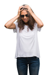 Wall Mural - Young hispanic woman wearing sunglasses suffering from headache desperate and stressed because pain and migraine. Hands on head.