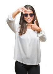 Sticker - Young beautiful arab woman wearing sunglasses over isolated background smiling making frame with hands and fingers with happy face. Creativity and photography concept.