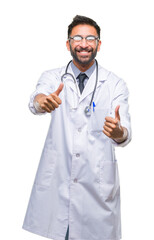 Wall Mural - Adult hispanic doctor man over isolated background approving doing positive gesture with hand, thumbs up smiling and happy for success. Looking at the camera, winner gesture.