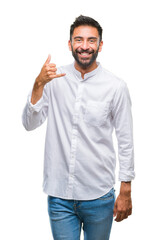 Poster - Adult hispanic man over isolated background smiling doing phone gesture with hand and fingers like talking on the telephone. Communicating concepts.