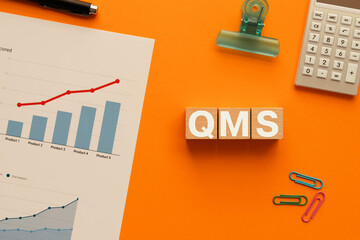 Wall Mural - There is wood cube with the word QMS. It is an abbreviation for Quality Management System as eye-catching image.