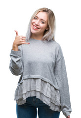 Poster - Young blonde woman over isolated background smiling doing phone gesture with hand and fingers like talking on the telephone. Communicating concepts.