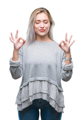 Poster - Young blonde woman over isolated background relax and smiling with eyes closed doing meditation gesture with fingers. Yoga concept.