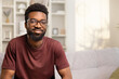 © puhhha - Smiling Young Man In Casual Home Setting Exuding Happiness And Confidence. Portrait Depicts Cheerfulness And Relaxed Lifestyle. Ideal For Ads, Magazines, And Positive Messaging.