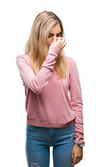 Canvas Print - Young beautiful blonde woman wearing pink winter sweater over isolated background tired rubbing nose and eyes feeling fatigue and headache. Stress and frustration concept.