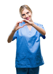 Wall Mural - Young beautiful blonde doctor surgeon nurse woman over isolated background smiling in love showing heart symbol and shape with hands. Romantic concept.