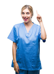 Poster - Young beautiful blonde doctor surgeon nurse woman over isolated background pointing finger up with successful idea. Exited and happy. Number one.