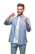 © Krakenimages.com - Young handsome man wearing white t-shirt over isolated background pointing fingers to camera with happy and funny face. Good energy and vibes.