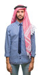© Krakenimages.com - Young handsome arabian business man wearing keffiyeh over isolated background with serious expression on face. Simple and natural looking at the camera.