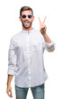 © Krakenimages.com - Young handsome man wearing glasses over isolated background smiling with happy face winking at the camera doing victory sign. Number two.