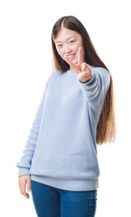 Wall Mural - Young Chinese woman over isolated background smiling looking to the camera showing fingers doing victory sign. Number two.