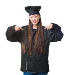 Sticker - Young Chinese woman over isolated background wearing chef uniform looking confident with smile on face, pointing oneself with fingers proud and happy.