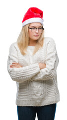 Poster - Young caucasian woman wearing christmas hat over isolated background skeptic and nervous, disapproving expression on face with crossed arms. Negative person.