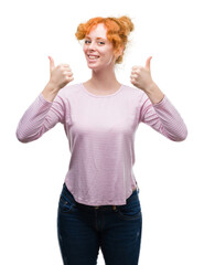 Sticker - Young redhead woman success sign doing positive gesture with hand, thumbs up smiling and happy. Looking at the camera with cheerful expression, winner gesture.