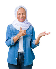 Sticker - Middle age eastern arab woman wearing arabian hijab over isolated background Showing palm hand and doing ok gesture with thumbs up, smiling happy and cheerful