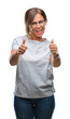 © Krakenimages.com - Middle age senior hispanic woman wearing glasses over isolated background approving doing positive gesture with hand, thumbs up smiling and happy for success. Looking at the camera, winner gesture.