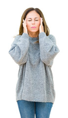 Wall Mural - Beautiful middle age woman wearing winter sweater over isolated background with hand on head for pain in head because stress. Suffering migraine.