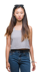 Wall Mural - Young asian woman wearing sunglasses over isolated background with serious expression on face. Simple and natural looking at the camera.