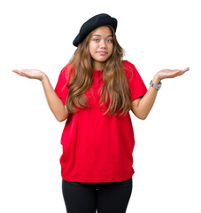 Wall Mural - Young beautiful brunette fashion woman wearing red t-shirt and black beret over isolated background clueless and confused expression with arms and hands raised. Doubt concept.