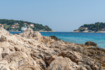 Poster - View from rugged rocky coastline across harbour to tourist and fishing township of Hvar