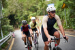 young professional asian cycling athletes training riding bike outdoors on rural road