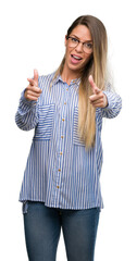 Canvas Print - Beautiful young woman wearing elegant shirt and glasses pointing fingers to camera with happy and funny face. Good energy and vibes.