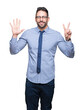 © Krakenimages.com - Young business man wearing glasses over isolated background showing and pointing up with fingers number seven while smiling confident and happy.