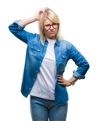 Wall Mural - Young beautiful blonde woman wearing glasses over isolated background confuse and wonder about question. Uncertain with doubt, thinking with hand on head. Pensive concept.