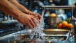 Close-up of hands being washed under running water from a tap, with water splashing.